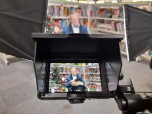 A photograph of Councillor Wye filming in Crewe Library