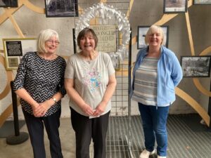 Photograph of Creative Crewe with their White Ribbon wreath in Crewe Market Hall