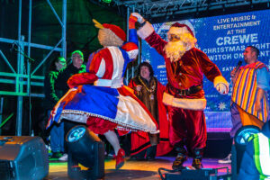 241130 Crewe Xmas Lights PR0349 Father Christmas dancing with pantomime dame Malcolm Lord at the Crewe Christmas Lights Switch On event
